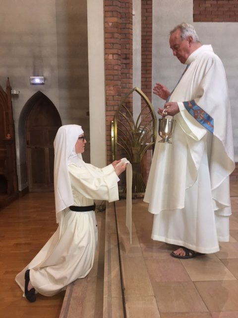 Sœur dominicaine prononçant ses vœux devant le célébrant